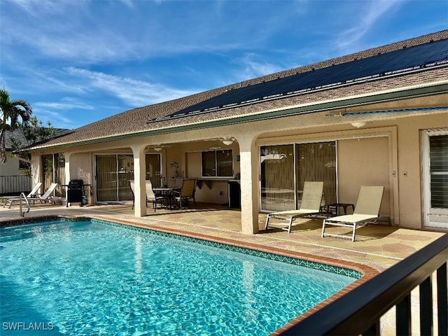 view of swimming pool featuring ceiling fan, a patio, and grilling area