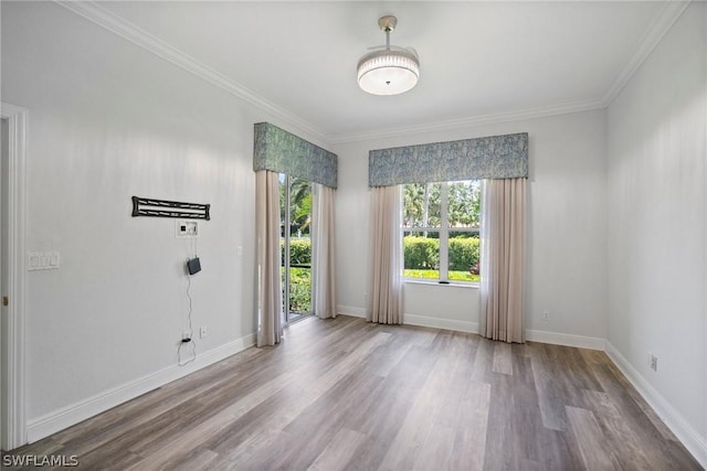 unfurnished room featuring crown molding, wood finished floors, and baseboards