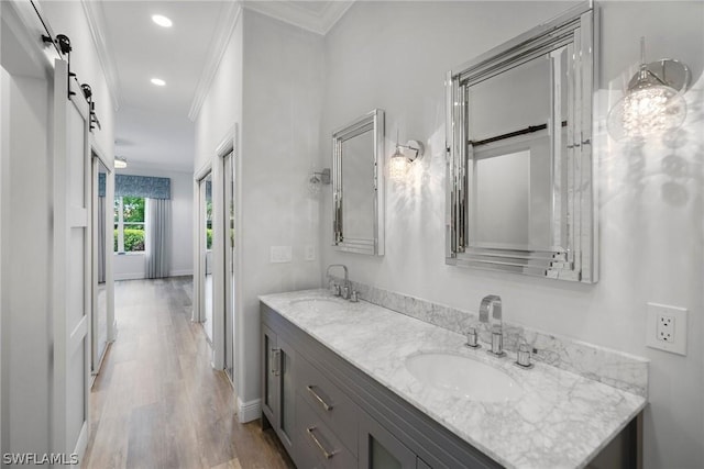 bathroom featuring double vanity, ornamental molding, a sink, and wood finished floors