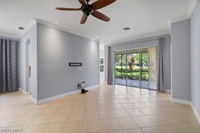 empty room featuring visible vents, crown molding, and baseboards