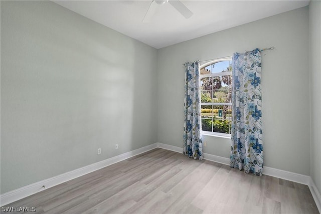 spare room with a ceiling fan, baseboards, and wood finished floors