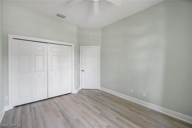 unfurnished bedroom with wood finished floors, a ceiling fan, visible vents, baseboards, and a closet