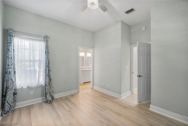 bedroom featuring visible vents, light wood-style flooring, baseboards, and ensuite bathroom