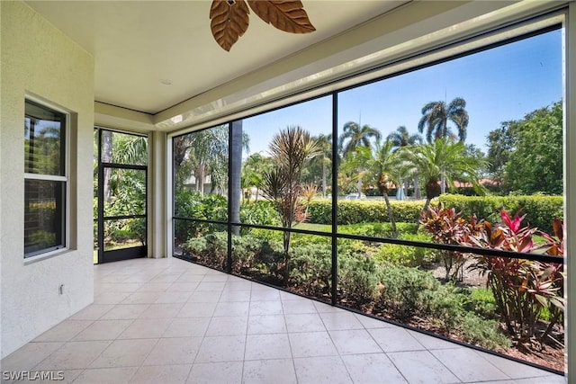 unfurnished sunroom with ceiling fan