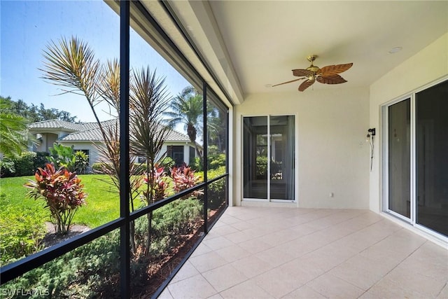 unfurnished sunroom featuring a ceiling fan