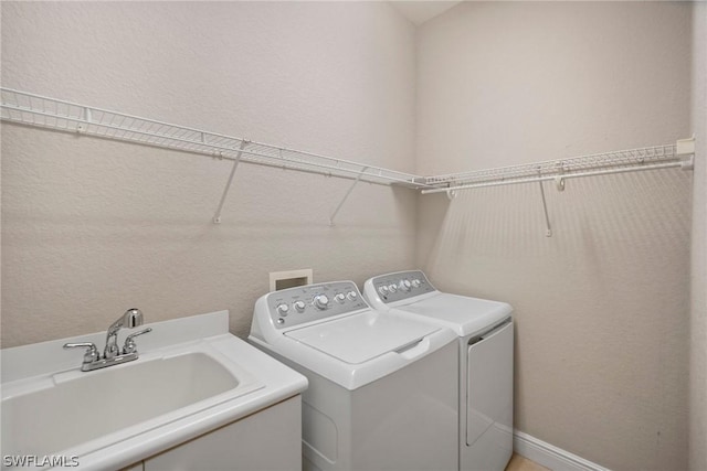 laundry room with laundry area, washing machine and dryer, and a sink