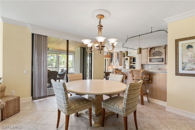 tiled dining area featuring ornamental molding and a notable chandelier