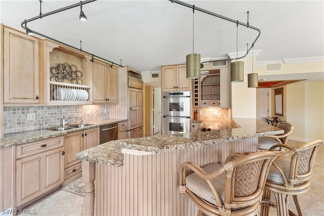 kitchen with backsplash, kitchen peninsula, light stone countertops, and stainless steel appliances