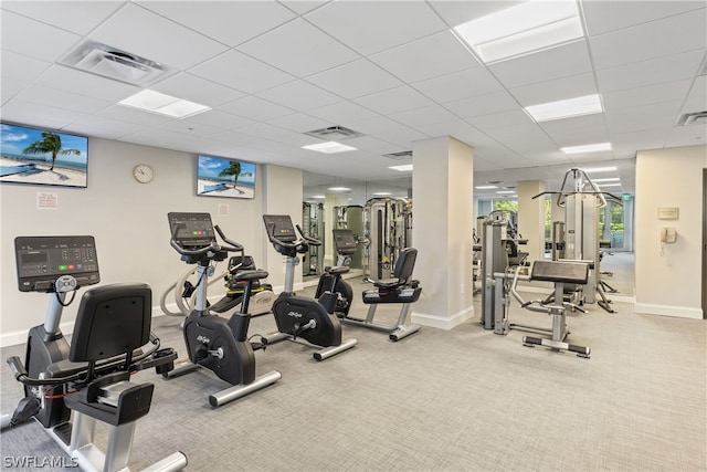 exercise room with a paneled ceiling and carpet floors