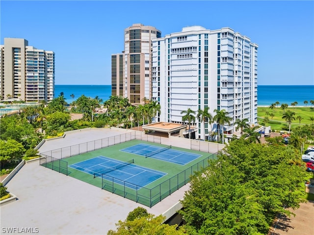 view of tennis court with a water view