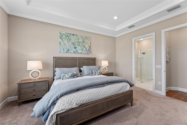 carpeted bedroom with a raised ceiling, ensuite bath, and crown molding