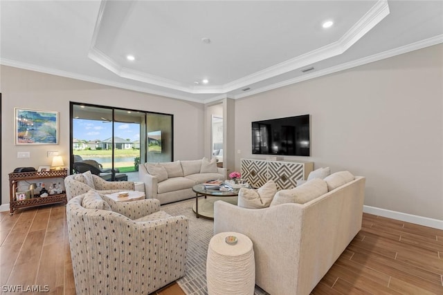 living room with a raised ceiling, light hardwood / wood-style floors, and ornamental molding