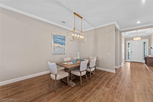 dining area featuring hardwood / wood-style flooring, a notable chandelier, and ornamental molding