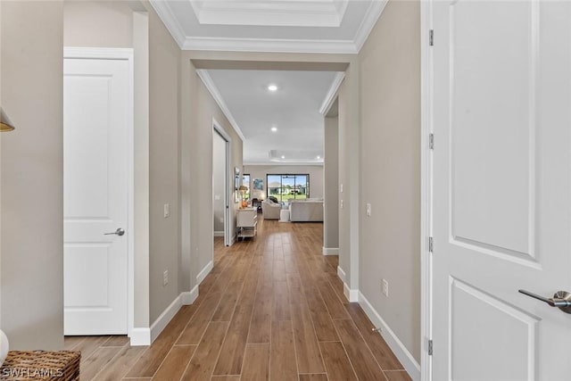 hall with light wood-type flooring and ornamental molding