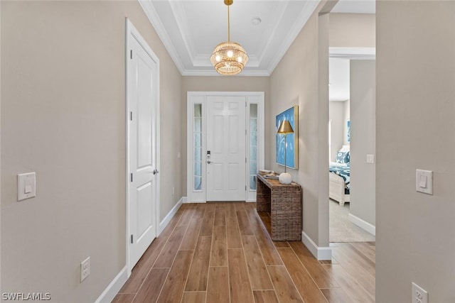 entrance foyer with an inviting chandelier, crown molding, and light hardwood / wood-style flooring