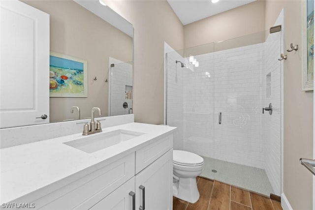 bathroom with hardwood / wood-style floors, vanity, toilet, and a shower with shower door