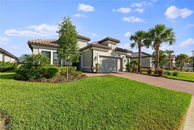 mediterranean / spanish-style house featuring a garage and a front lawn