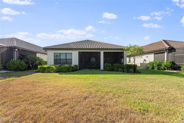 rear view of house with a sunroom and a yard