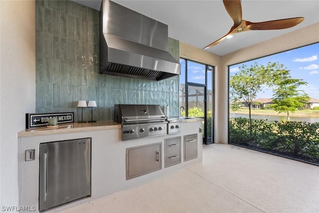 kitchen with stainless steel fridge, wall chimney exhaust hood, tile walls, and ceiling fan