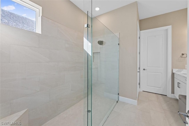 bathroom with tile patterned flooring, vanity, and tiled shower