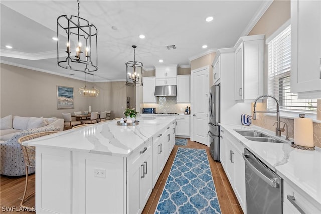 kitchen featuring sink, stainless steel appliances, dark wood-type flooring, a spacious island, and white cabinets