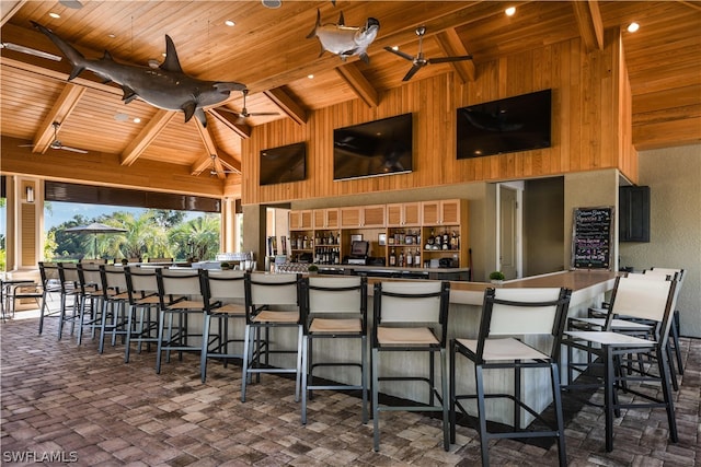 kitchen with a kitchen breakfast bar, ceiling fan, beamed ceiling, and wood ceiling