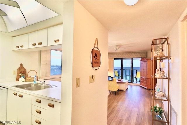 corridor featuring a water view, hardwood / wood-style flooring, and sink