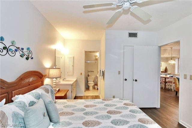 bedroom with ensuite bathroom, ceiling fan, sink, hardwood / wood-style flooring, and a closet