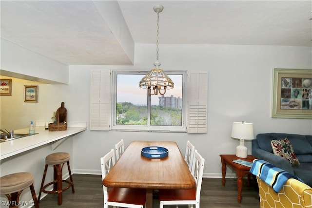 dining room with dark hardwood / wood-style floors and an inviting chandelier