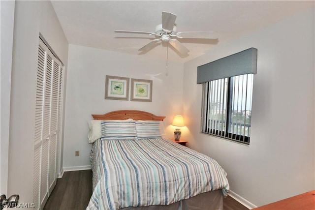 bedroom with ceiling fan, dark wood-type flooring, and a closet