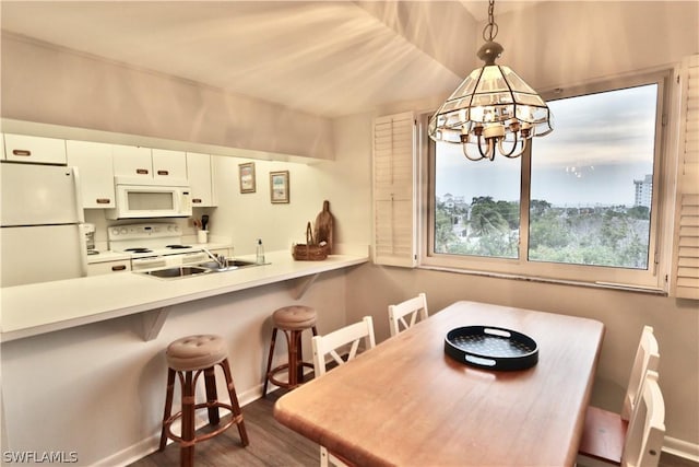 dining room with dark hardwood / wood-style flooring, sink, and a notable chandelier