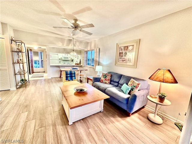 living room with ceiling fan and light hardwood / wood-style floors