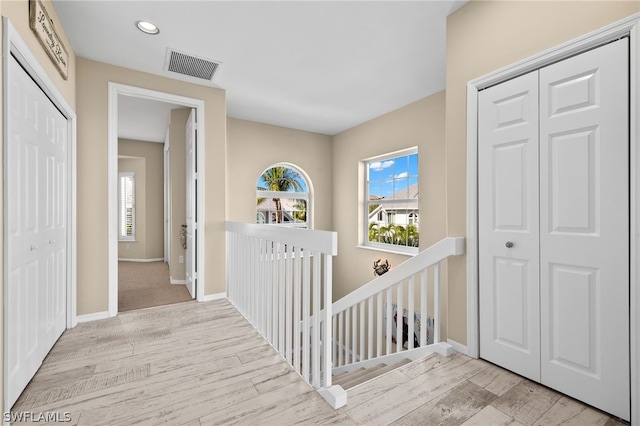 corridor featuring light hardwood / wood-style flooring and a wealth of natural light