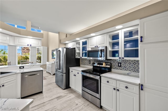 kitchen featuring white cabinets, light stone countertops, and stainless steel appliances