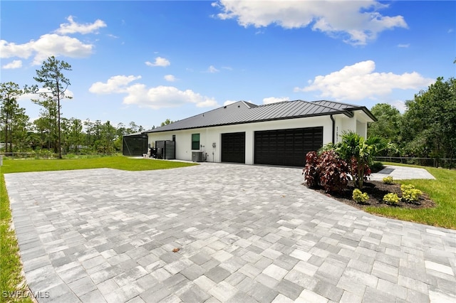 view of front facade featuring cooling unit, a front yard, and a garage