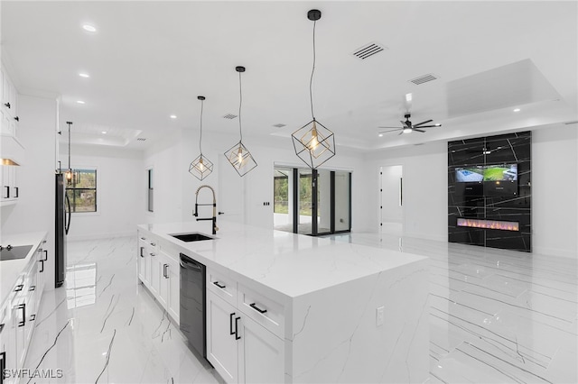 kitchen featuring ceiling fan, sink, decorative light fixtures, black appliances, and a spacious island