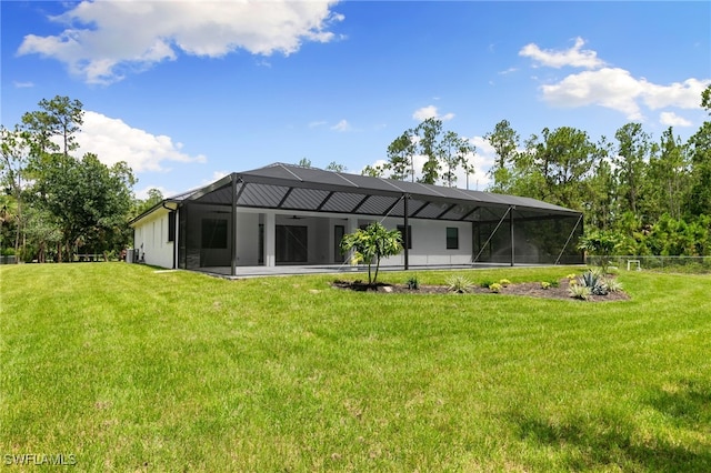 rear view of property featuring a yard and glass enclosure