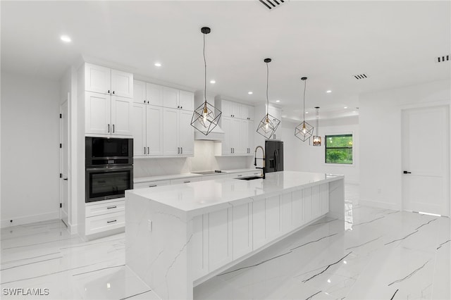 kitchen with a large island, white cabinets, and black appliances