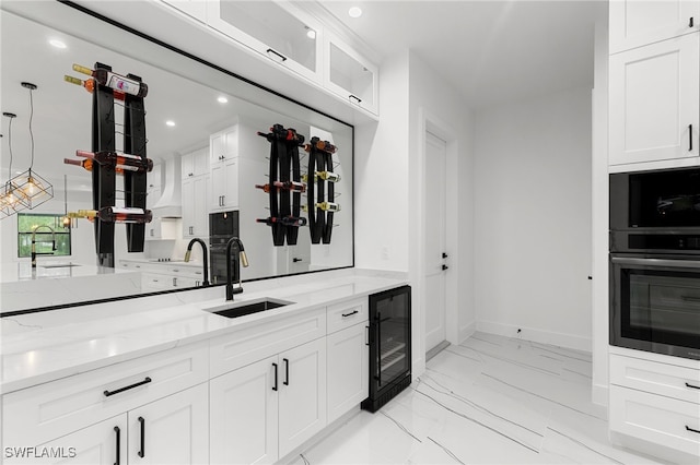 kitchen featuring white cabinets, wine cooler, and sink