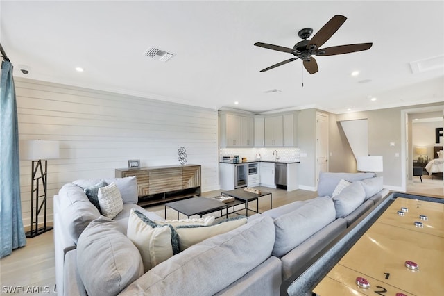 living room with ceiling fan, light hardwood / wood-style floors, and sink