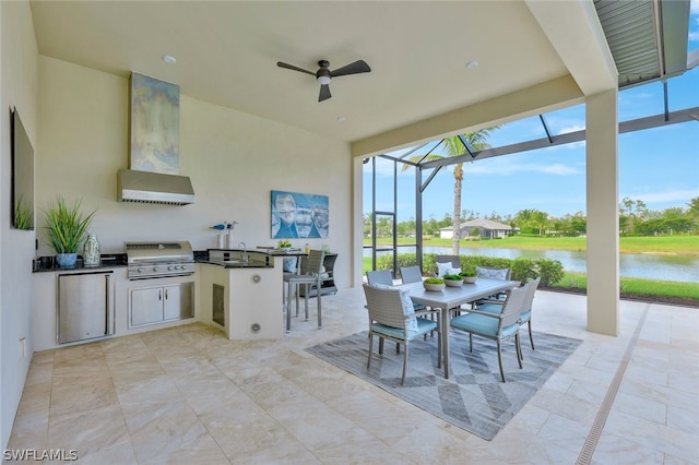 view of patio / terrace with grilling area, an outdoor kitchen, a water view, ceiling fan, and a lanai