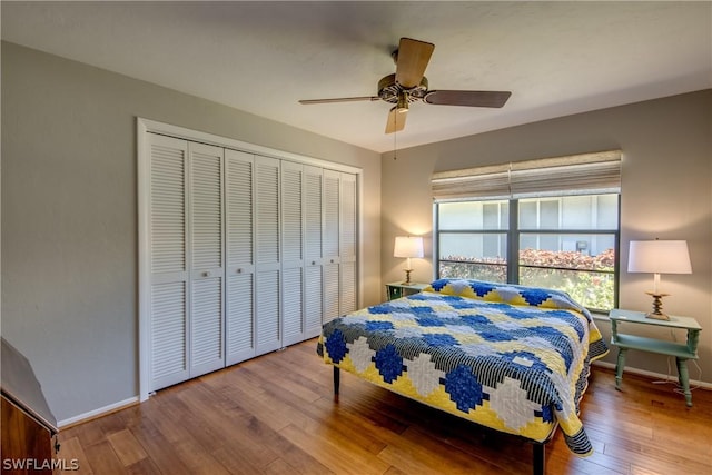 bedroom with a closet, hardwood / wood-style floors, and ceiling fan