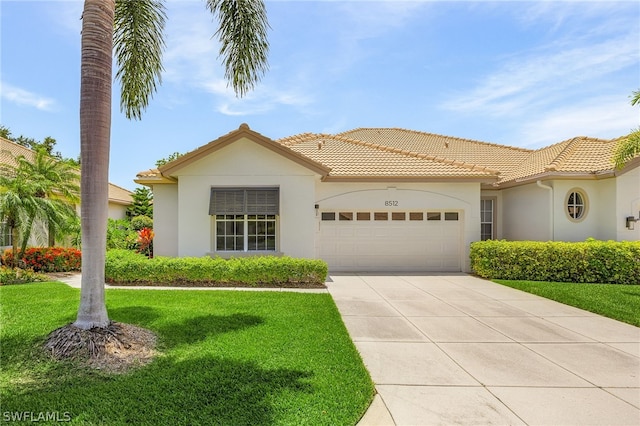 mediterranean / spanish house featuring a garage and a front lawn