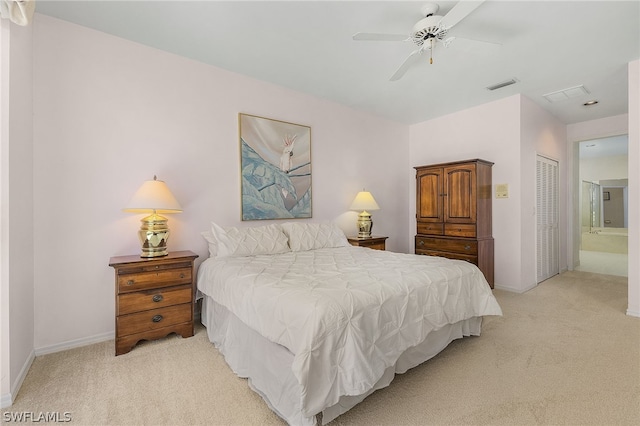 bedroom with ceiling fan, light colored carpet, connected bathroom, and a closet