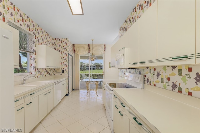 kitchen with white appliances, sink, light tile patterned floors, decorative light fixtures, and white cabinetry