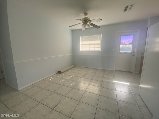 tiled empty room with ceiling fan