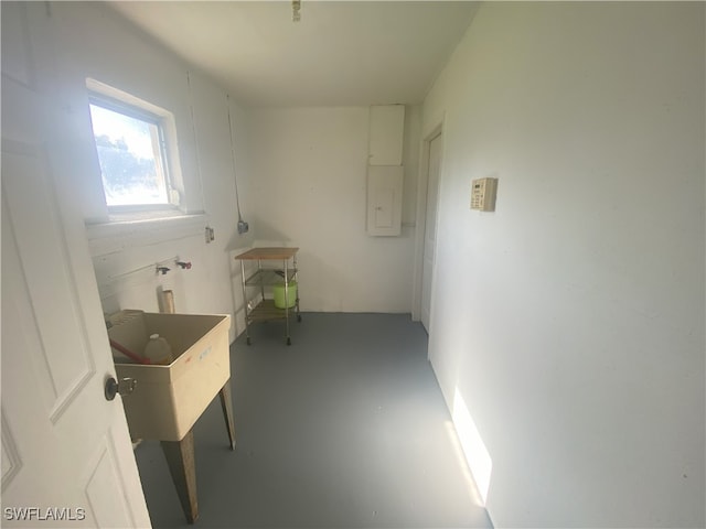 interior space with electric panel, concrete floors, and sink