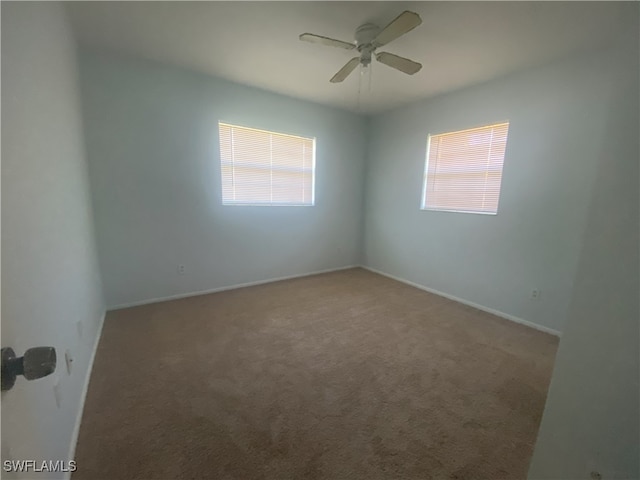 carpeted empty room featuring a wealth of natural light and ceiling fan