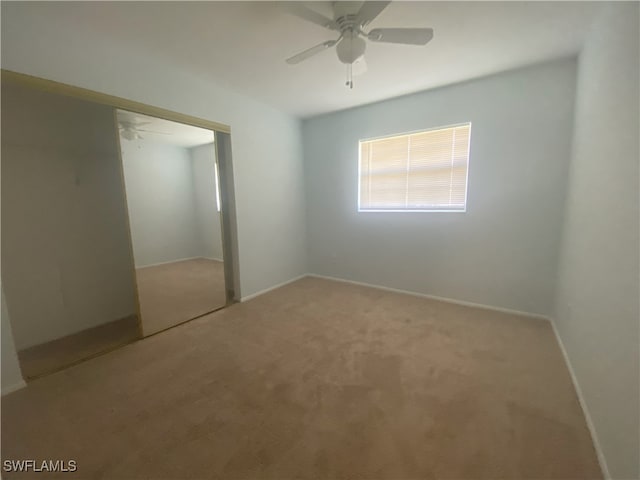 unfurnished bedroom featuring ceiling fan, light colored carpet, and a closet