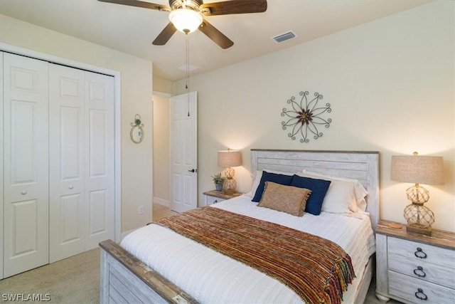 bedroom featuring visible vents, a ceiling fan, a closet, and light colored carpet